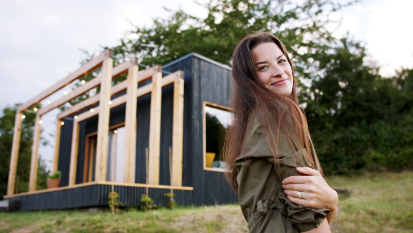 Young woman spinning outdoors, weekend away in container house in countryside.
