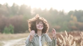 young pretty mixed race teen girl outdoor in sunlight. happy child of generation z laughs and adjusts her finely curly hair. - Powered by Shutterstock - Get 15% off with code: PIKWIZARD15