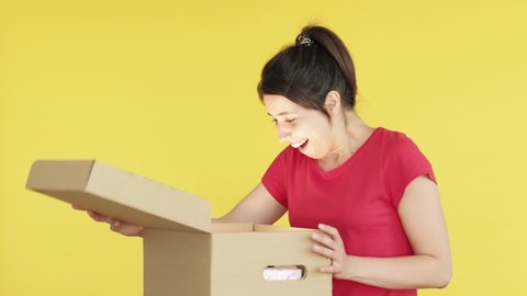 Gift surprise. Wish come true. Excited woman feeling happy opening big present box. Isolated on yellow copy space. Pleasant purchase. Shopping bonus. Unexpected delivery
