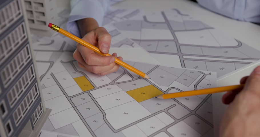 urban planning - businessmen discussing about territory building plots on cadastral map fot apartment building construction Royalty-Free Stock Footage #1060609318