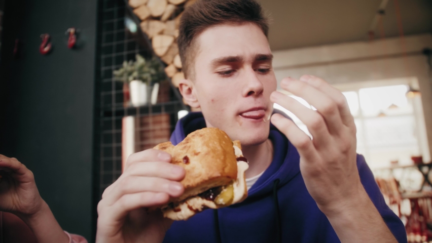 Man eating burger. Close up. Junk food, modern life concept. | Shutterstock HD Video #1060609369