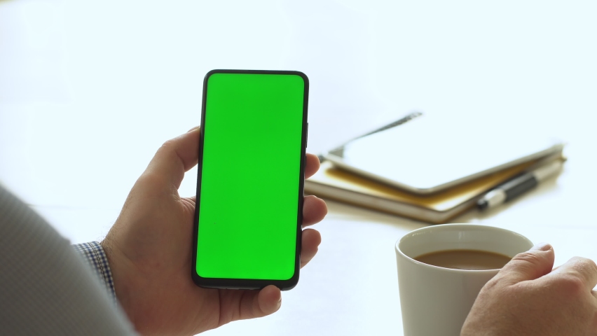Handheld Camera: Point of View of Man at Room Sitting on a Chair Using Phone With Green Mock-up Screen Chroma Key Surfing Internet Watching Content Videos Blogs Tapping Screen | Shutterstock HD Video #1060610470