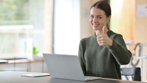 Young Woman with Laptop showing Thumbs Up 