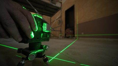 Laser measurement during renovation. Construction tools and equipment. Green laser light lines for level measure.