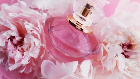 Pink perfume bottle with peony flowers, chic fragrance scent as luxury cosmetic, fashion and beauty product background, stock footage