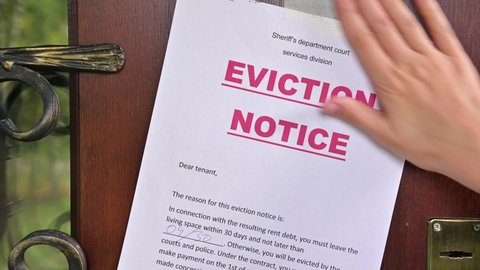 A resident's eviction notice is glued to the front door of the house, close-up