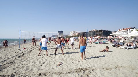 Durres, Albania - circa Aug, 2020: Group of friends playing beach volley - Multi-ethic group of people having fun on the beach