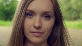 The face of a beautiful girl with natural makeup, long blonde hair. Goes forward. 4K video.