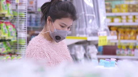 New normal lifestyle Asian mature adult female woman shopping in supermarket with face mask protection