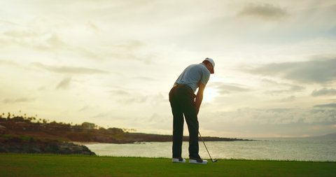 Sunset golf, man swinging and hitting golf ball at sunset