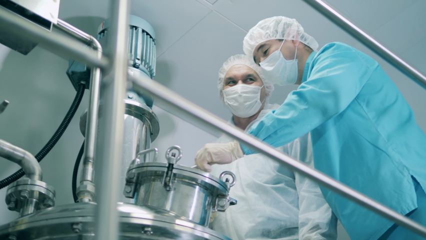 Men in medical coats work with machine in laboratory. Royalty-Free Stock Footage #1060636036