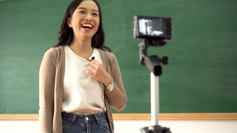 Young woman providing remote lesson using video camera, technology, remote learning, online education. Asian school teacher delivering online course