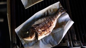 Dorado fish cooking on grill in seafood restaurant
