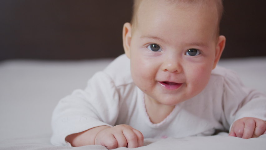 Close up slow motion of lovely little baby girl smile indoor portrait of infant smile. | Shutterstock HD Video #1060641919