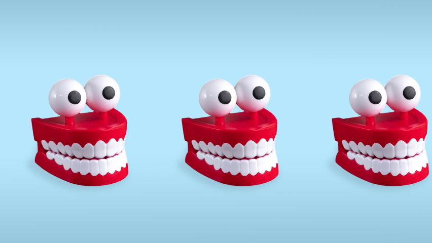 seamless looping animation of one row chattering teeth toys with big eyes on a blue pastel background. plastic red mouths with white fangs is a concept of oral hygiene and healthy teeth