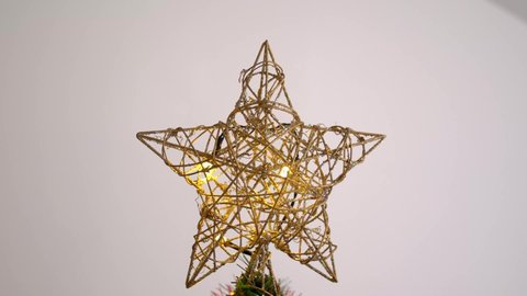 Golden braided Star tree topper on top of Christmas tree. Camera slowly moving down and revealing beautiful decoration and ornaments