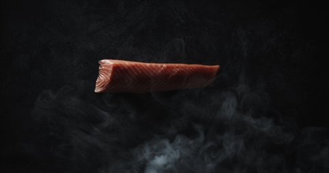 Smoking A Slab Of Fresh Salmon Meat, A process of preparation of sushi is Philadelphia, burning of smoking fire of fresh raw red fish salmon tuna eel