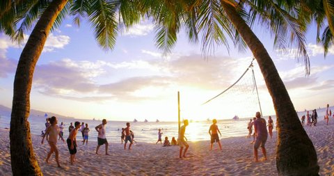 BORACAY, PHILIPPINES 9 FEB 2015: Unidentified tourist play beach volley ball at sunset on sandy beach of tropical island while being on summer holidays