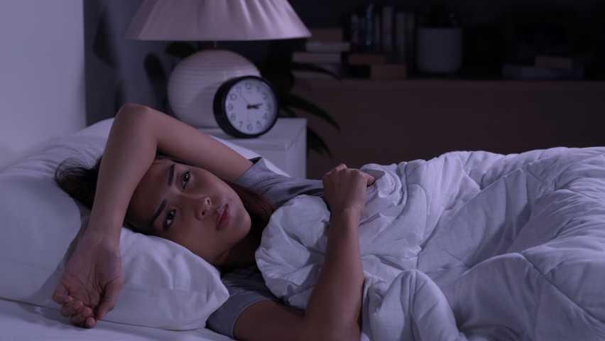 Depressed young Asian woman cannot sleep from insomnia. Depressed woman suffering from insomnia lying in bed. Royalty-Free Stock Footage #1060658419