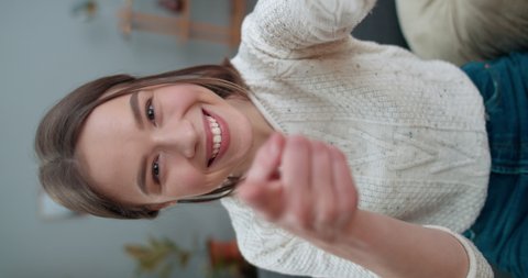 Crop view of young female person having video call and using smartphone frontal camera. Happy woman smiling and saying with sign language Hello, how are you Vertical video