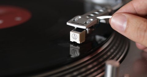 Vinyl playing. A man putting a vinyl music at home. Close up