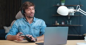 Confident Young Coach, Mentor, Business Analyst is teaching Online, holding Webinar, Seminar. Handsome Freelancer Businessman is holding Online Conference from Home Office, wearing Headphones.