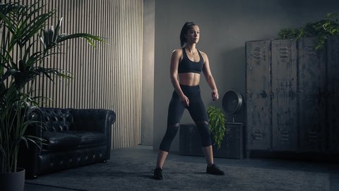 Slender figure of woman doing squat training. Healthy women in sportswear doing squat at home. Home fitness workout. Slow motion.
