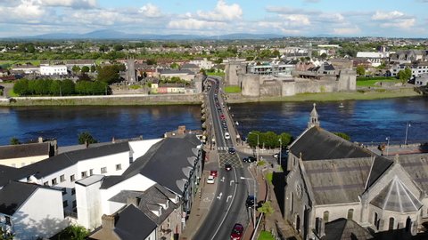 Limerick City, Ireland. Drone Aerial View of Thomond Bridge Above Shannon River and King John's Castle on Riverbank on Sunny Summer Day