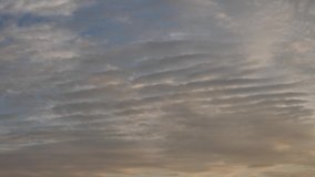 Corrugated clouds flying in the sky at sunset, slightly blurred