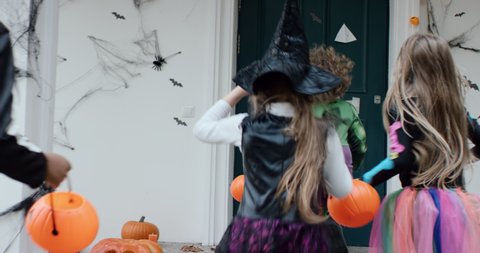 TRACKING Group of trick-or-treating kids running and knocking the door during Halloween. Shot on RED camera with 2x Anamorphic lens