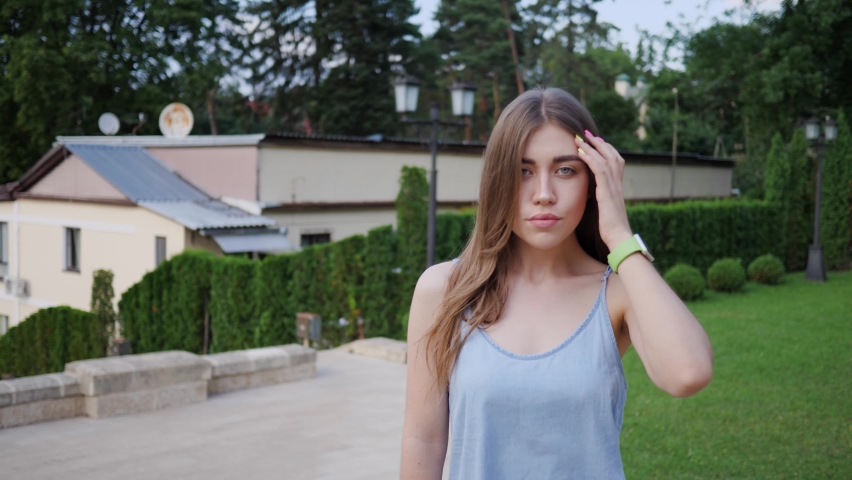 Portrait of young beautiful woman model and tourist posing for camera against background of city attractions.