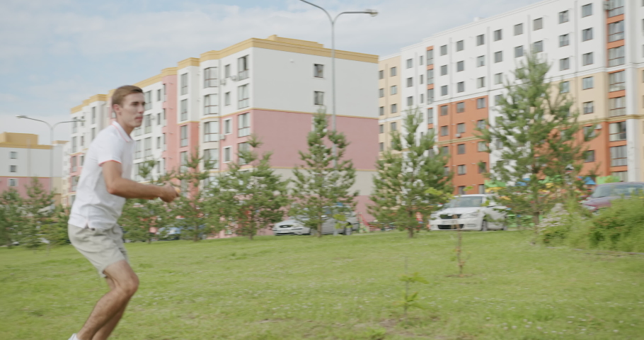 A group of friends playing flying disc on the street.