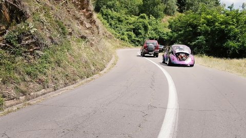 Kocani, Macedonia - 24 Jun, 2020: VW Beetle custom car drive downhill on rural road at old modified car meeting
