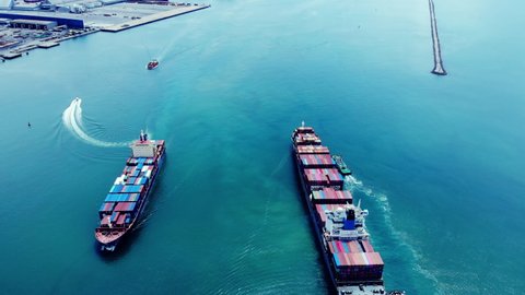 Aerial top view of 2 cargo ship carrying container running opposite directions for export import near  cargo yard port concept freight shipping by cargo ship .