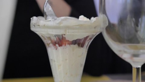 Closeup of delicious Vanilla icecream in desserts cup, spoon scooping, static