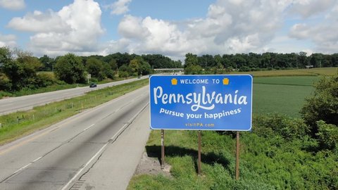 Baltimore , MD / United States - 08 23 2020: Welcome to Pennsylvania, sign along Route 83 entering PA from Maryland, Mason Dixon line, aerial during summer day with beautiful sky and clouds