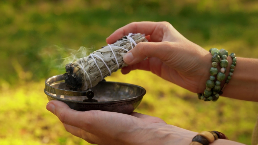 occult science and supernatural concept - young woman or witch with smoking white sage performing magic ritual in forest Royalty-Free Stock Footage #1060692457