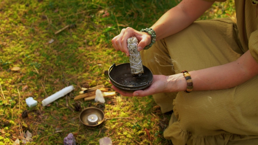occult science and supernatural concept - young woman or witch with smoking white sage performing magic ritual in forest Royalty-Free Stock Footage #1060692634
