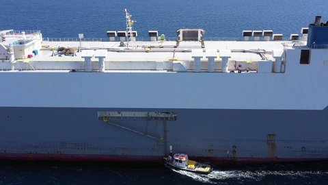Pilot boat approaching a large Car Carrier Ship, Aerial view.