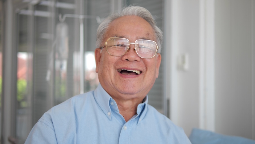 Happy Asian older senior adult man looking at the camera in hospital. healthy cheerful senior patient retired with smiling face portrait. Royalty-Free Stock Footage #1060697803