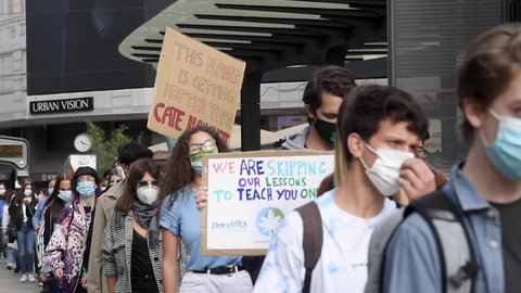 Milan, Italy - 9 October 2020: A student wearing protection mask for the covid19 coronavirus holds a placard during the Fridays For Future rally to demand action against climate change.