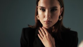 Close-up portrait of caucasian young brunette woman with bright makeup posing in studio. Concept for advertising a womens perfume in an online store, steadicam shot