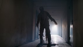 Guy in thematic bandaged costume of halloween mummy doing a cool breakdance in hallway of haunted house, representing halloween in funny way 4k footage