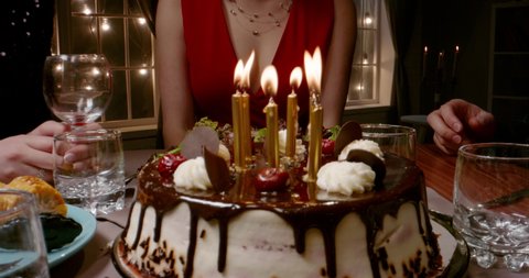 Group of multiethnic friends celebrating birthday, clapping and cheering. Beautiful caucasian girl is blowing out candles on birthday cake - happy people, holidays, friendship concept 4k footage