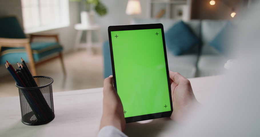 Close up shot of hands golding a tablet computer with mock up chroma key green screen. Template for online education and video conferences 4k footage