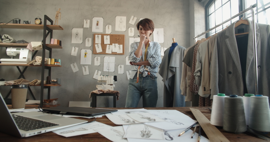 Authentic female fashion designer wandering around her office, looking for inspiration for new collection - fashion, small business, art concept 4k footage | Shutterstock HD Video #1060702654