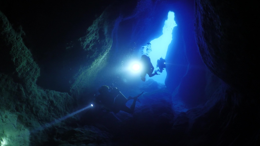 Cave diving underwater scuba divers exploring caves and having fun ocean scenery sun beams and rays background | Shutterstock HD Video #1060703650