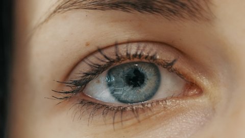 Close-up of female eye opening with beautiful blue iris.