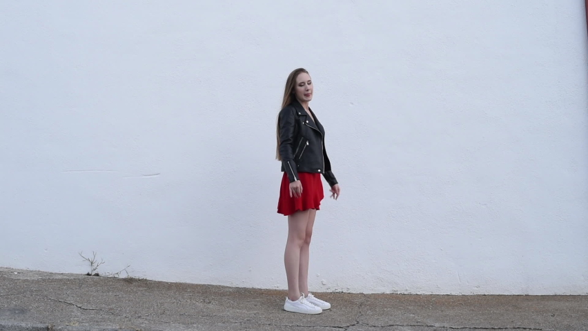 blonde girl jumping white wall background