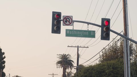 Red traffic lights and no u-turns sign, on Washington Boulevard, overcast day, in Los Angeles, California, USA - Static view